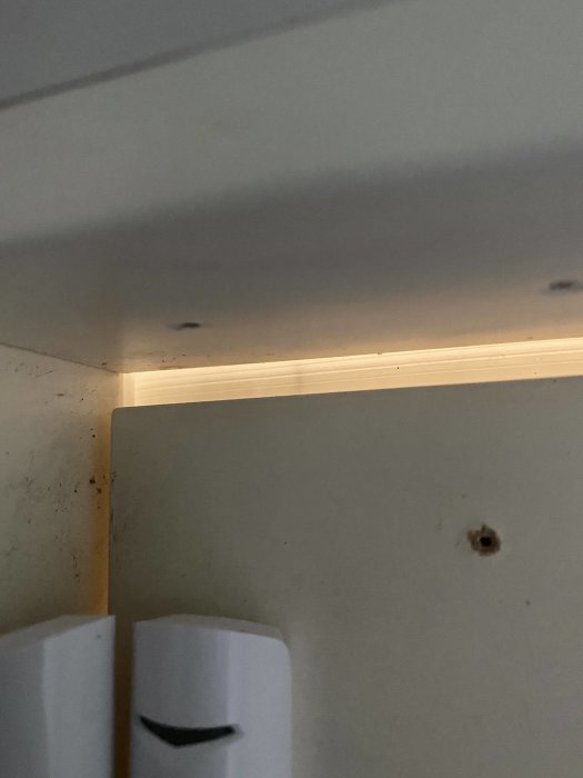 Övre delen av en dörr med synligt glapp i karmen och tätningslist, indikation på otäthet.