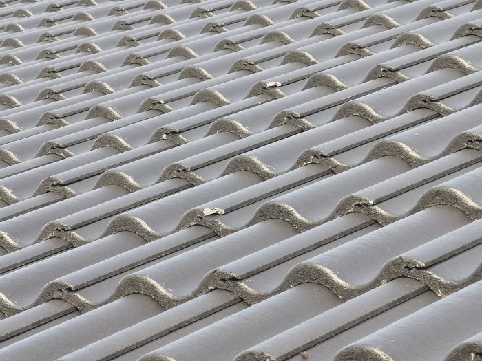 Närbild av takpannor med synliga skador och glipor på ett nylagt tak.