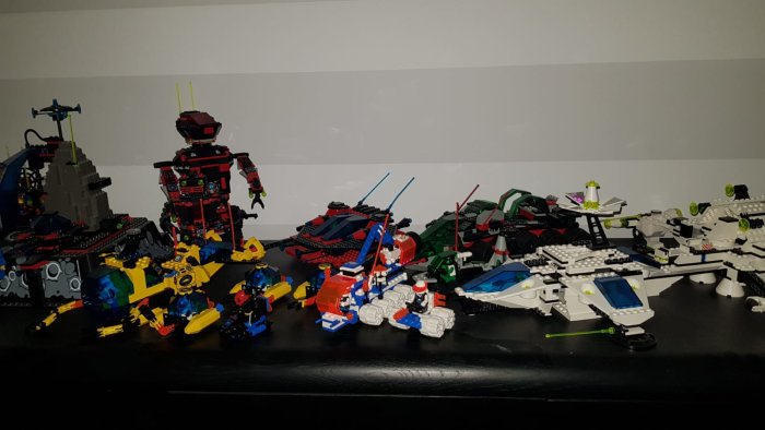 Samling byggda Lego-modeller från 90-talet, inkluderar rymdskepp och robotar.