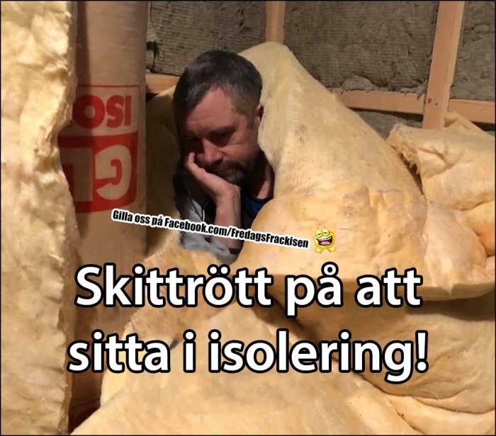 Man sitter trött mellan isoleringsmaterial på en byggarbetsplats, med texten "Skittött på att sitta i isolering!".