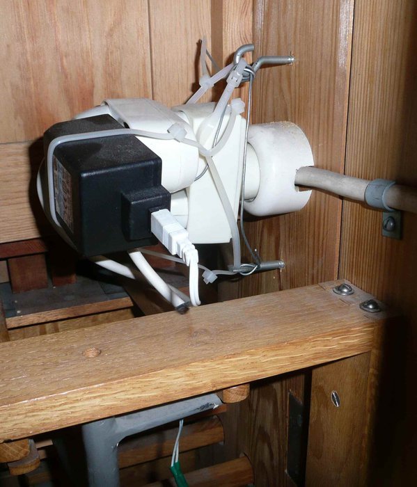 Nätadapter kopplad till en apparat med sladdar bundna runt en vit plastarmatur.