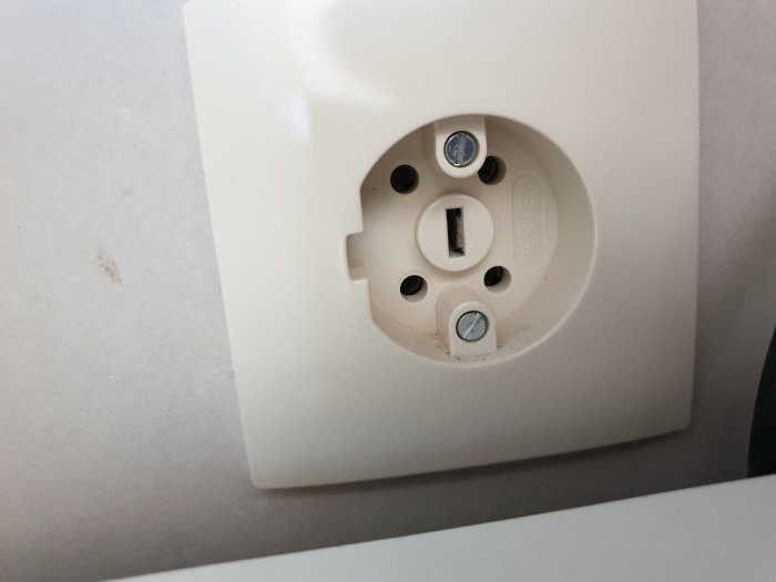 Ett 230V PERILEX vägguttag för ugn, med fyra hål och en jordanslutning.