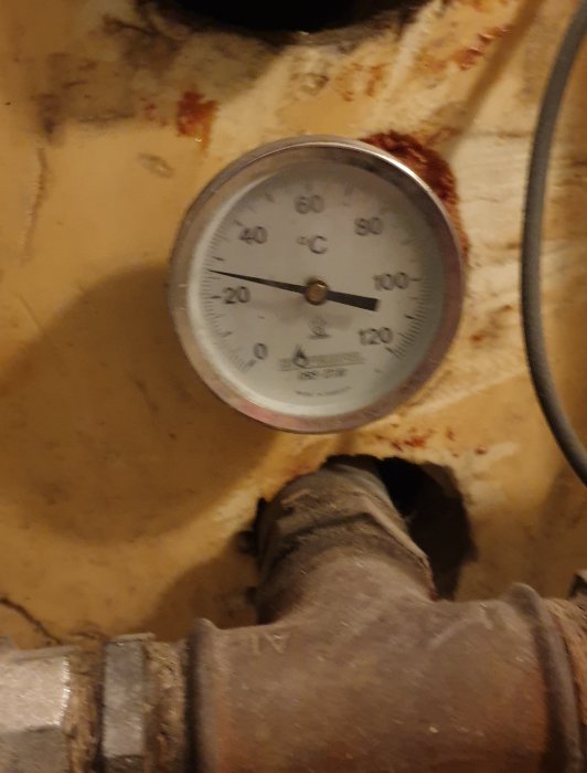 Termometer på en ackumulatortank visar ungefär 30 grader Celsius i en uppvärmningsanläggning.