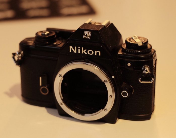 Ett använt analogt Nikon EM kamerahus utan objektiv, troligen för demontering och återanvändning av delar.