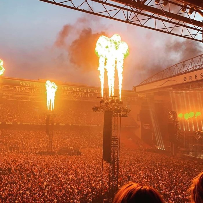 Konsertpublik med uppåtgående flammar från scenen på Rammsteins livekonsert i Köpenhamn.