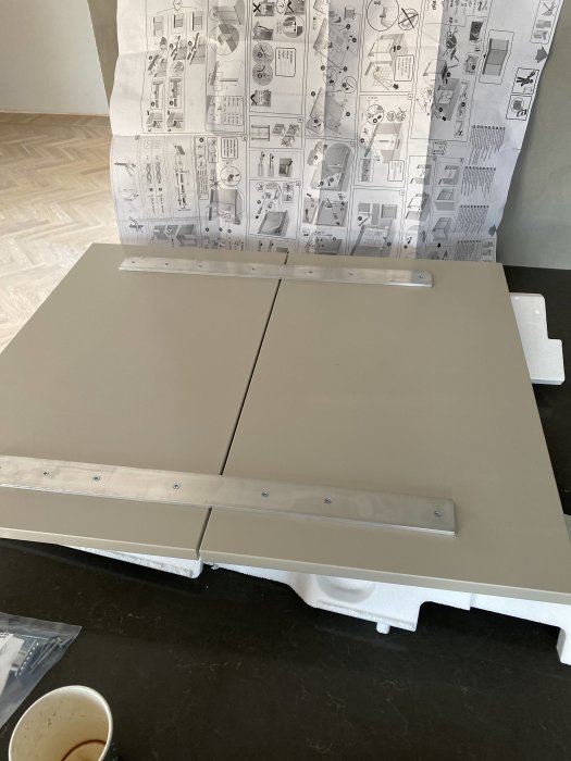 Bosch diskmaskinslucka på bänk med monterade metallskenor och instruktionsmanual i bakgrunden.