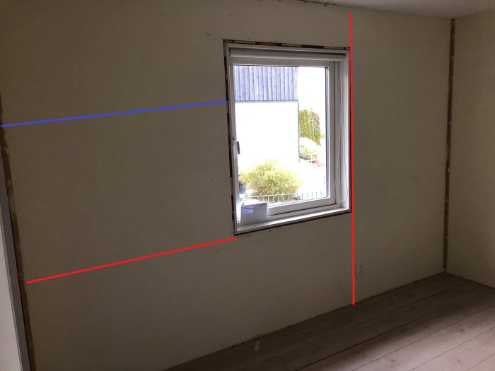 Rum med spånskivor på väggar markerade med röda och blåa linjer som visar reglar och skarvar.
