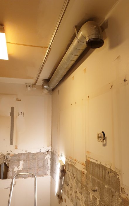 Ventilationsrör i taket av en kök under renovering, med rörövergång som planeras att kapas.