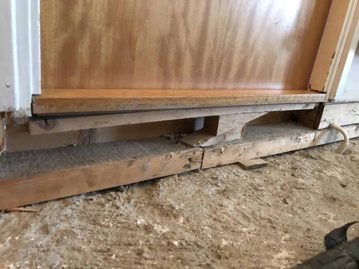 En tröskel som inte stöder kanterna på ett undergolv under renovering.