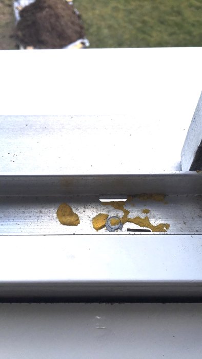 Sektion av ett fönsterkarm med okänt segt gult material som kanske är rester från insekter.