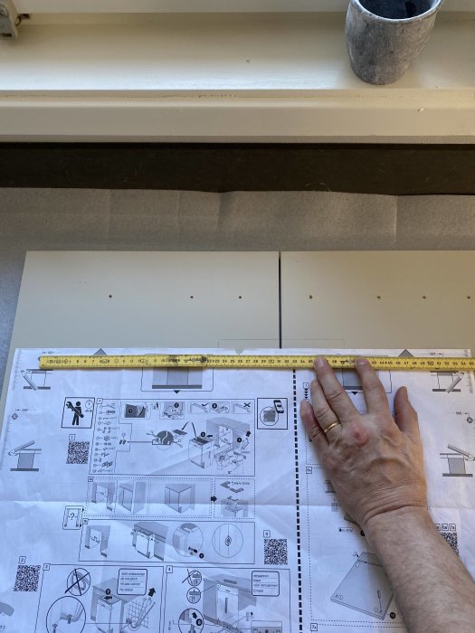 Hand som håller tumstock mot Boschs diskmaskinsmall där måtten visar en 4mm skillnad från faktiska luckan.