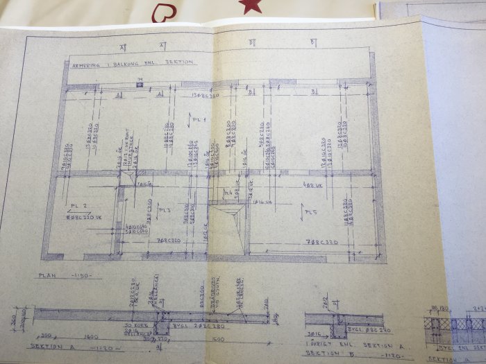 Planritning av en byggnad som visar betongbjälklagens riktning och placering av bärande väggar och pelare.