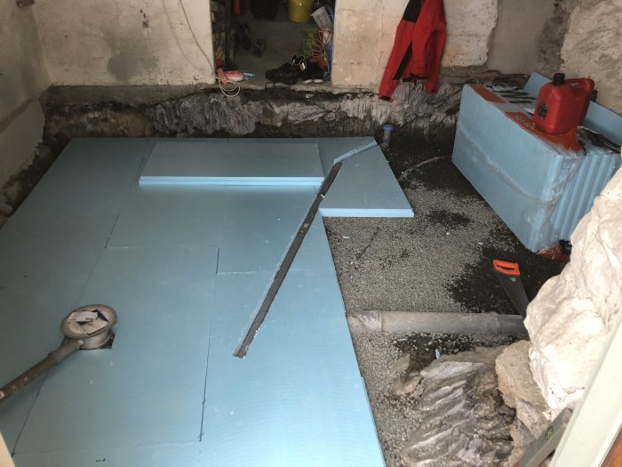 Renoveringsprojekt av källare med nyinstallerade blå isoleringsplattor och rostfri Purus golvbrunn.