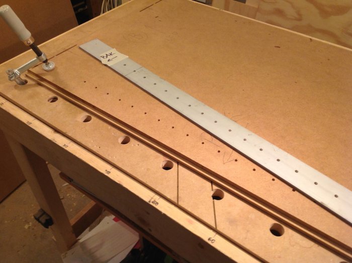 Verktygsbord med hålmall i aluminium fastspänd för borrning, anpassat för precisionsarbete i snickeri.