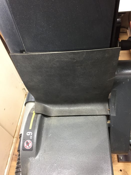 Slipmaskins anhåll med uppsatt gummiduk för att fånga slipdammet, och gul markering för 6-tums mått.