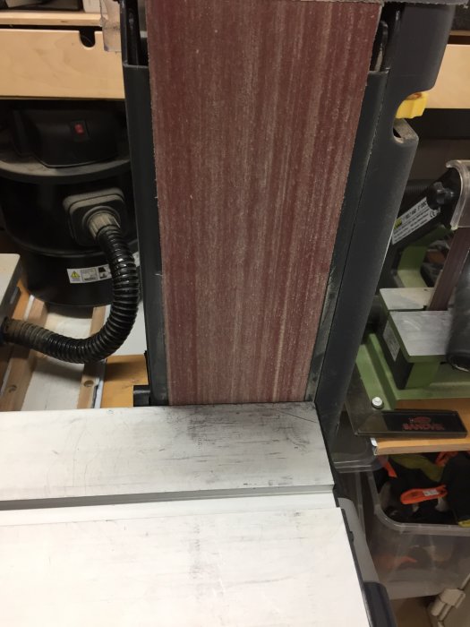 Slipmaskin med dammuppsamlingsanordning bestående av kardborreband, gummiduk och plaströr.