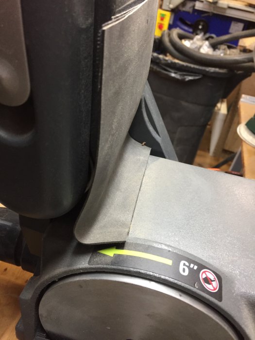 Slipmaskin närbild med gummiduk och kardborreband använda för att fånga slipdammet, delat plaströr syns i toppen.