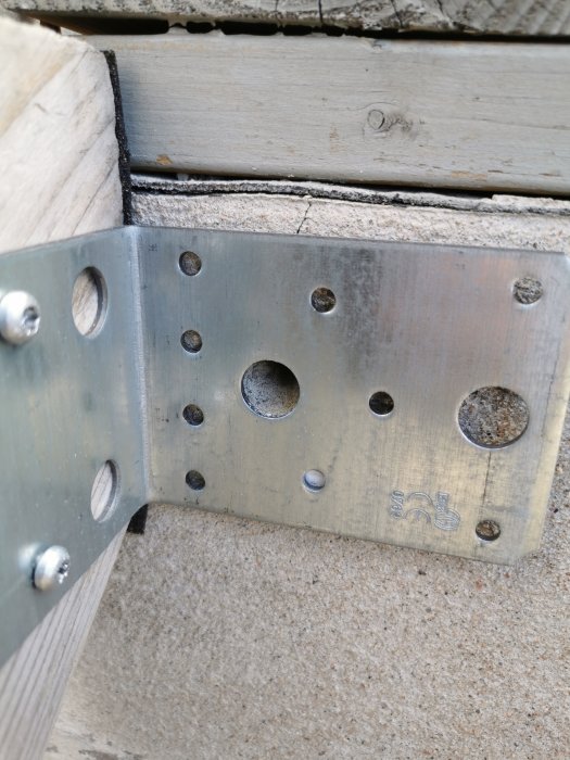 Metalldel av en trappvang monterad nära kanten på en gammal sprucken betongveranda.