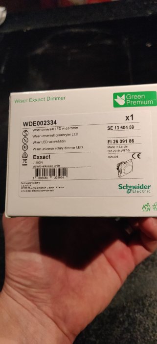 Förpackning av Wiser Exxact Dimmer för LED-lampor som hålls i en hand.