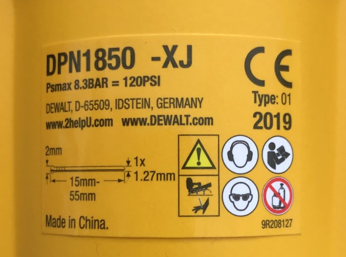 Etikett på DEWALT DPN1850-XJ dyckertpistol med specifikationer för tryckluft och spikstorlek.