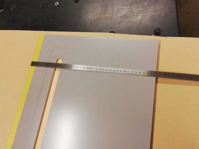 Mätverktyg visar 380mm på ett skuret bräde trots att det planerades vara 390mm.