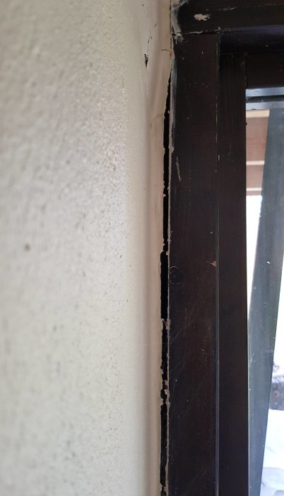 Spricka vid fönsterkarmen inuti ett hus som kan tyda på sättningar i byggnaden.