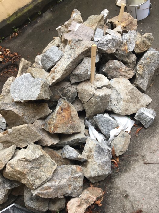 Hög av sprängda stenblock och småsten efter markarbeten för golvläggning.