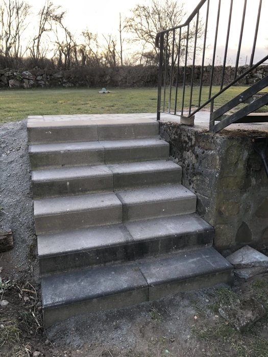 Renoverad utomhustrappa med nya släta steg och nymålat räcke.