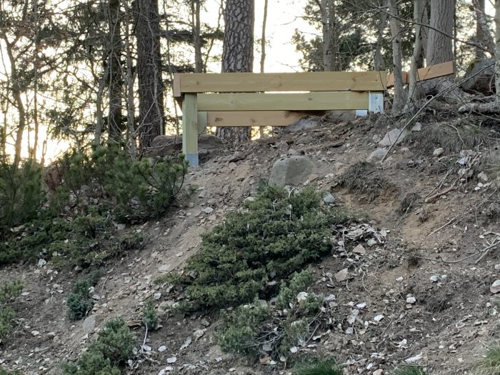 Stadigt byggd kojgrund av spillvirke på en stenig sluttning med omgivande vegetation.