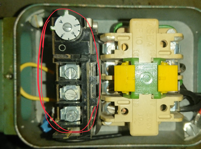 Elektriskt motorskydd med strömjusteringsvred inringat i rött och kontaktor till höger.