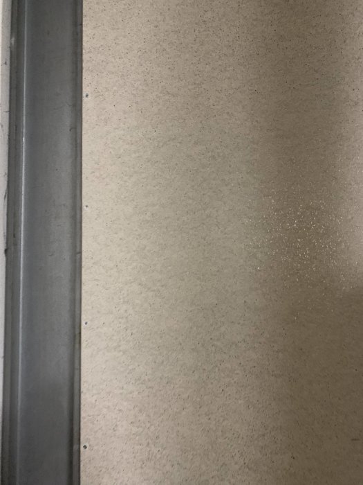 Cementgipsskiva monterad på vägg intill en metallprofil, i ett utrymme som kan påminna om en källare.