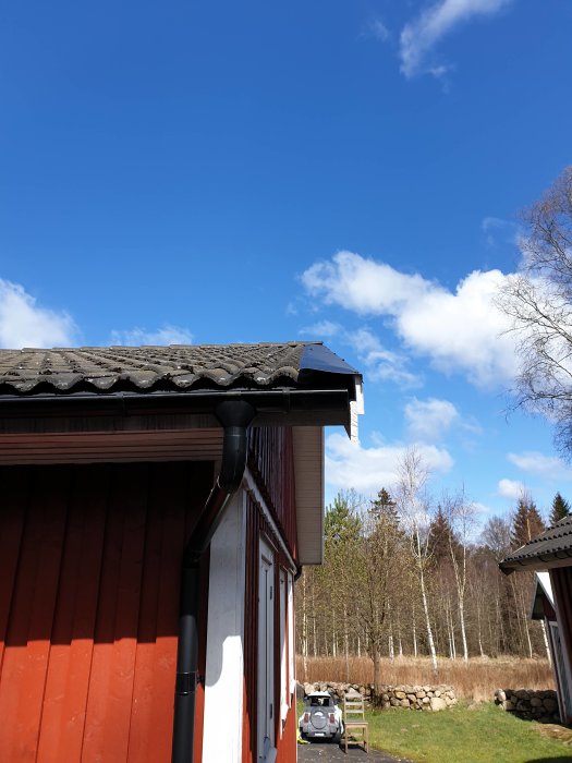 Vindskiveplåtar på hus med röda väggar och tegeltak som ligger på takpannornas nock med en uppåtvinkel.