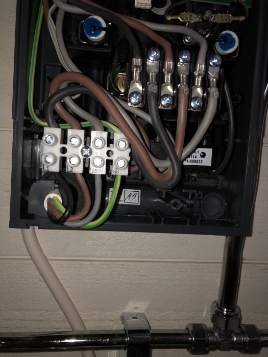 Elskåp öppet med synliga ledningar och kopplingar, märkt med Metro Therm, antyder norskt ursprung.