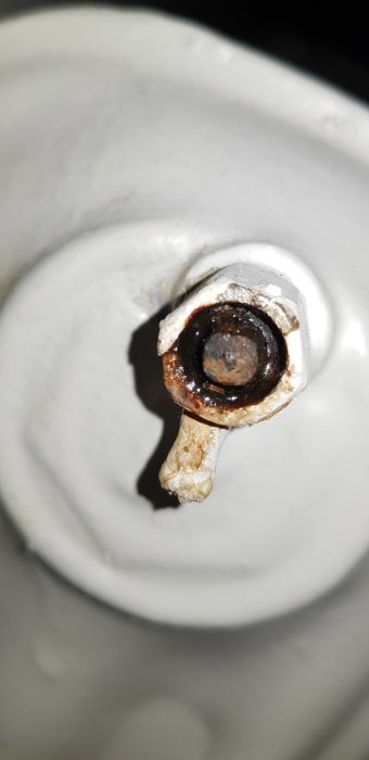 Rostig luftningsventil på ett element med en gammal elementnyckel fast i öppningen.