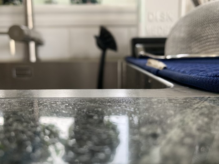 Närbild på kanten av en diskbänk som putar uppåt i det nedre vänstra hörnet.