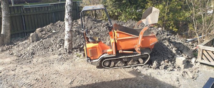 Minidumper i arbete med fyllnadsmassa av jord och lera på en tomt.