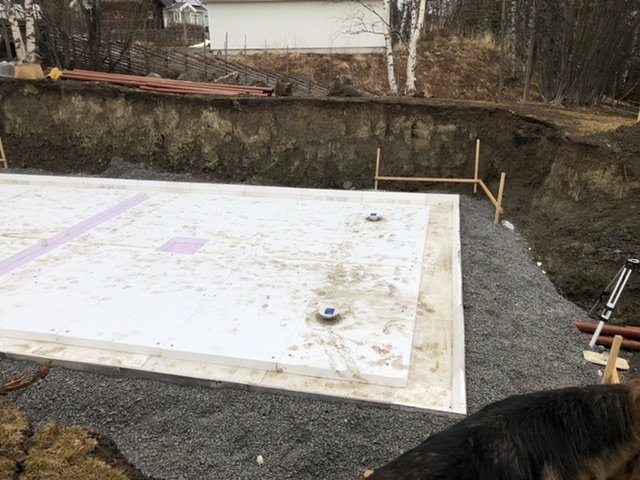 Lagd frigolit och kantelement på en grusgrund med grävda sidor på en byggarbetsplats.