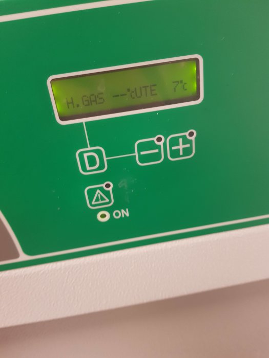 Digital display på en apparat som visar texten "H.GAS --CUTE 7%" med symboler för batteri, varning och påslagning.