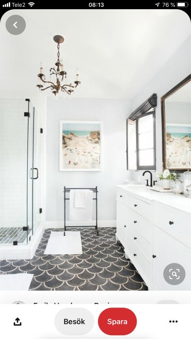 Modern badrum med svartvita kontraster, mönstrat golv, vit kommod och en duschhörna.