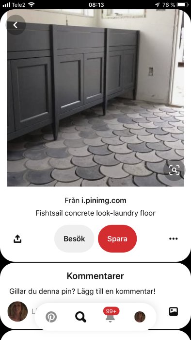 Grå tvättstugeinredning mot vägg med svartvit, fiskskal-mönstrad betonglook på golvet.