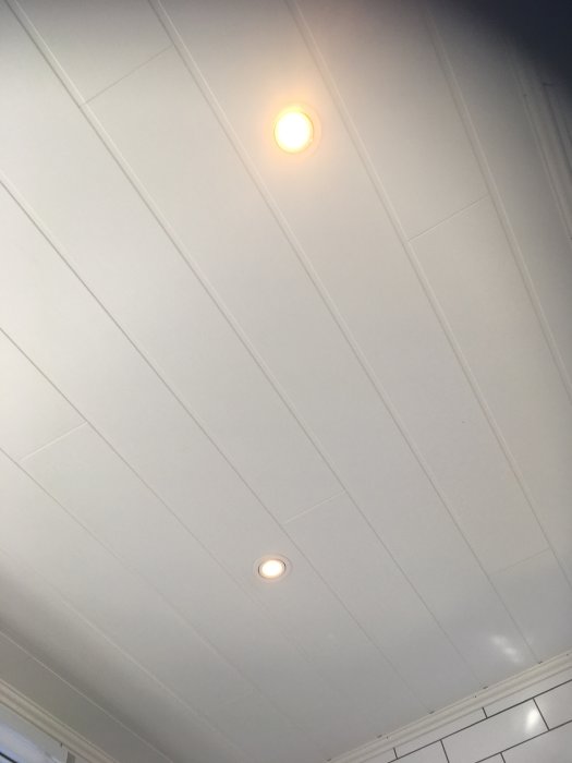 Nyinstallerade spotlights i ett vitt badrumstak.