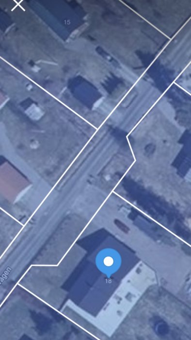 Flygbild som visar tomtgränser och hus, inklusive en blå platsmarkör.