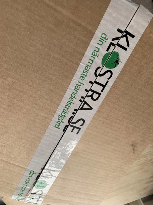 Kartong med förseglingstejp markerad med "KRAV" och en grön groda som symboliserar ekologiska produkter.