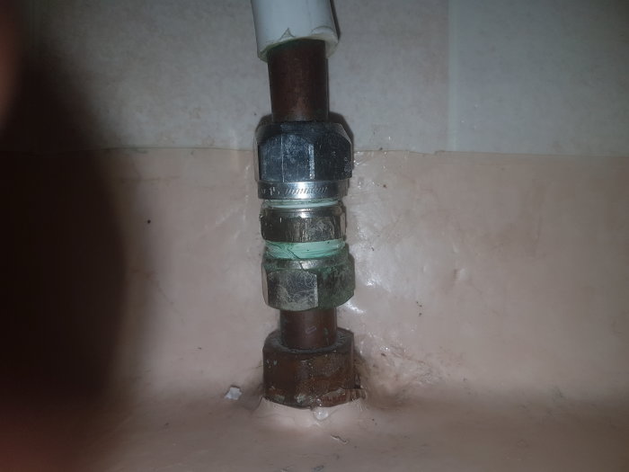 Ett befintligt toalettanslutningsrör med kopplingar och tejp mot en vägg, tänkt att ersättas enligt frågeställarens beskrivning.