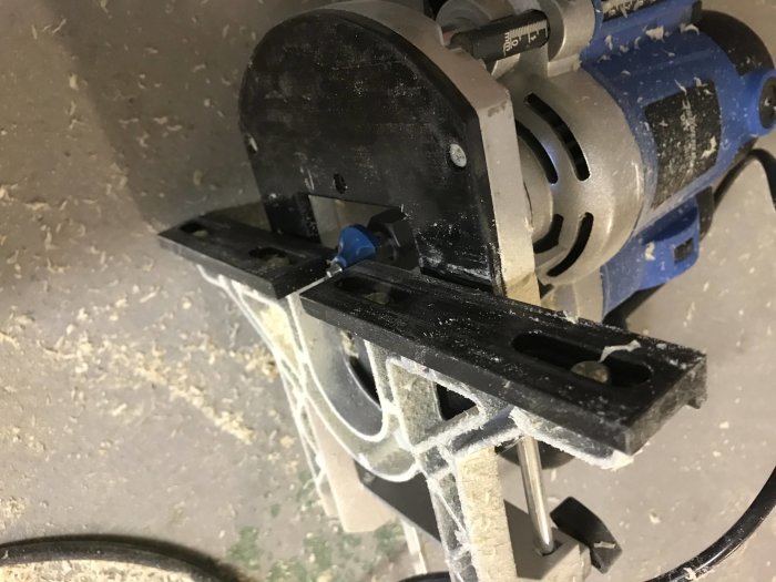 Elverktyg med borttaget lager använder anhåll för träbearbetning, täckt av spån.