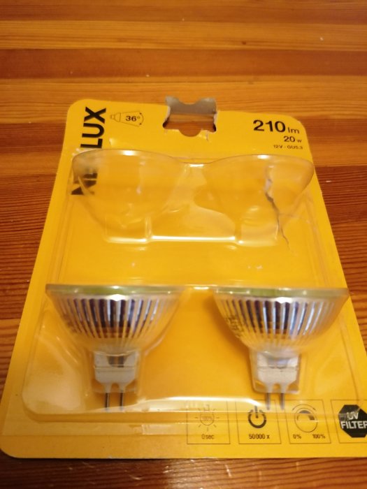 Förpackning med två halogenlampor GU5.3, 210lm och 20W utan dimmerfunktion på ett träbord.