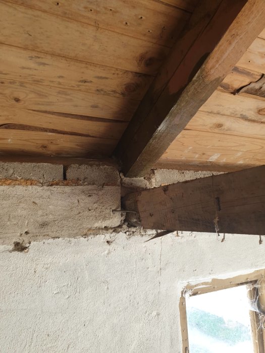 Takstolar infällda i en betongvägg över en dörröppning i en verkstadsbyggnad, som ska renoveras.