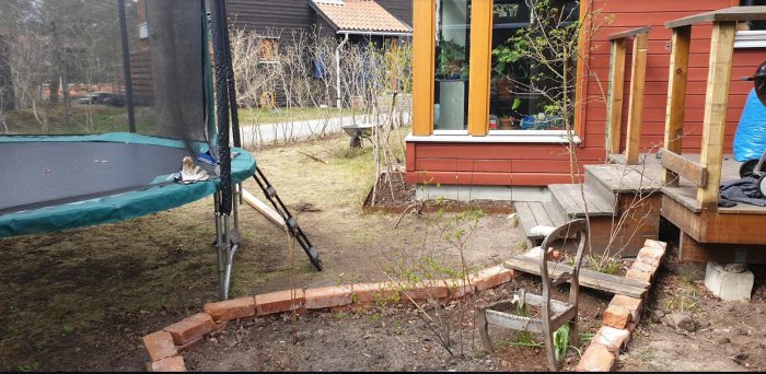 Altan i behov av restaurering och utbyggnad med bärlina, betongfundament och plintar, bredvid ett hus och en studsmatta.