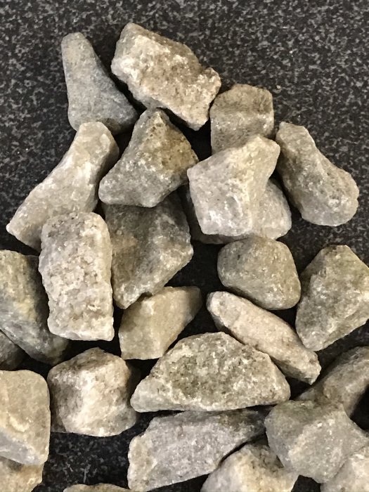 Närbild av gråa kvartsitstenar i storleken 8-11mm med variationer i vitt och grått.