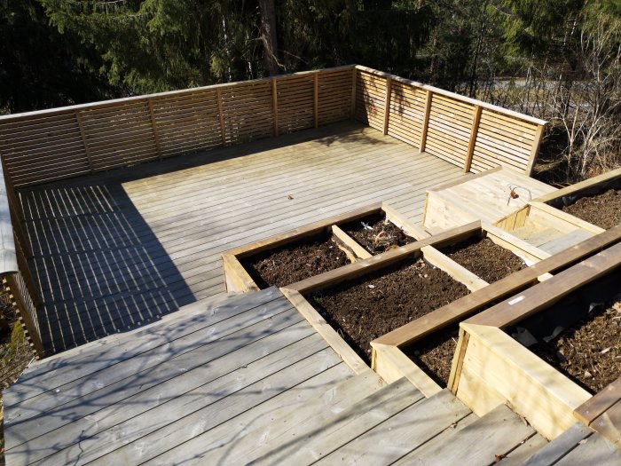 Befintlig terrass på pålar med träplankgolv och räcken, förberedd för pergolabygge.